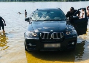 «Машина проехала через весь пляж». BMW решила искупаться в озере — водителя наказала ГАИ